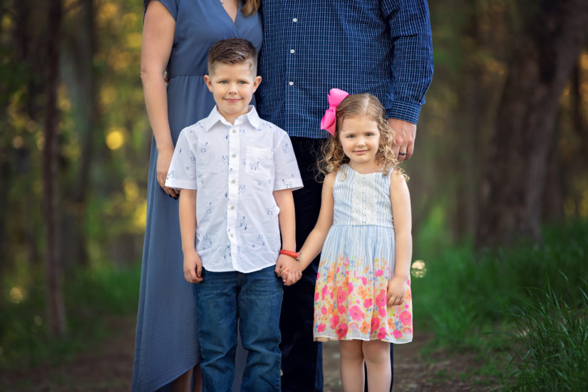 brother and sister holding hands in front of parents - Nashville Family Photographer